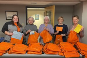 A group of Altrusa Volunteers along with the  Urbana Kindergarten Coordinator, Kelly Allen, put together orange kindergarten readiness bags.