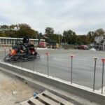 Machine smoothing the foundation for the addition at the 6th grade center