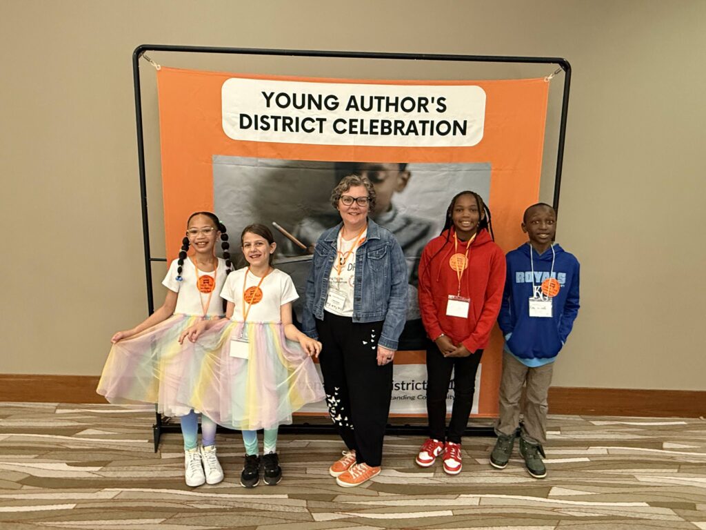 Students at Dr. Williams Elementary who participated in the Young Authors contest pose in front of the Young Authors banner at the ihotel.