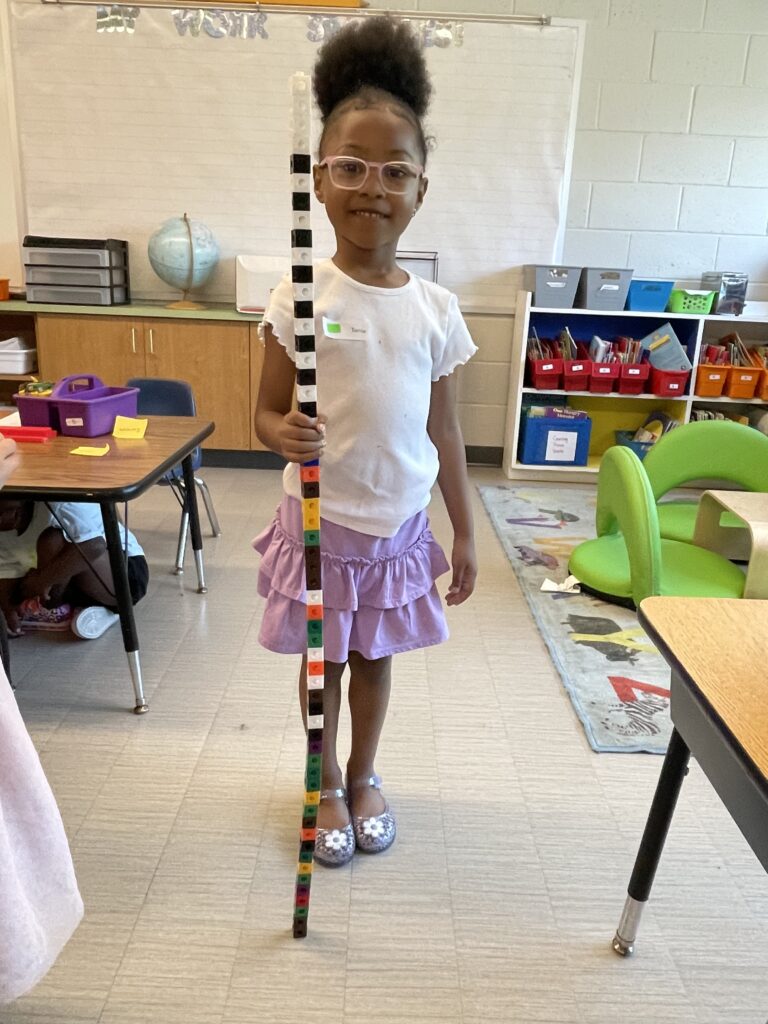 Student standing with a block tower in front of her